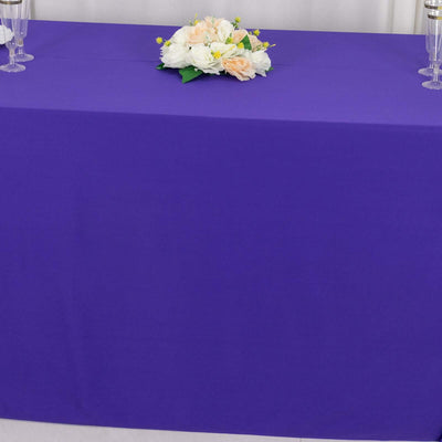 Purple tablecloth with floral centerpiece arrangement.