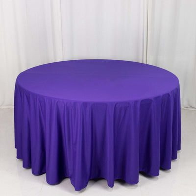 Purple round tablecloth on a white backdrop.