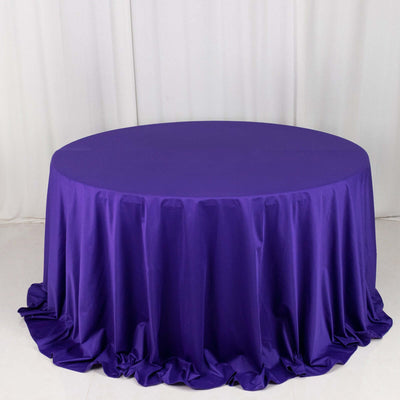 Purple round tablecloth on a white backdrop.