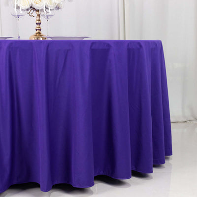 Purple tablecloth draped over a table in a styled setting.