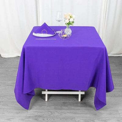 Purple tablecloth draped over a table set with decorative items.