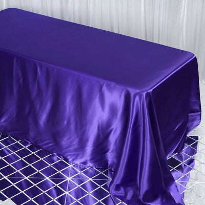 Purple satin tablecloth on a reflective surface.