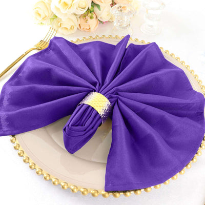 Purple napkin elegantly arranged on a decorative plate.