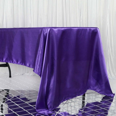 Purple satin tablecloth draping elegantly over a reflective surface.