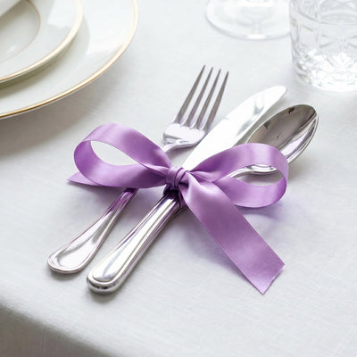 Elegant table setting with silver cutlery tied in a lavender ribbon