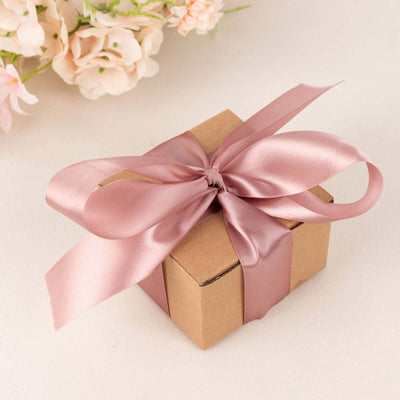 Brown gift box with a pink satin ribbon on a neutral background.