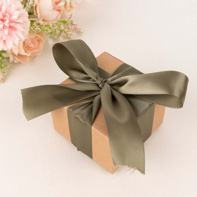 Small gift box with olive green ribbon on a soft surface