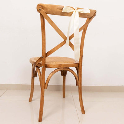 Wooden cross-back chair with a ribbon, showcasing a natural finish.