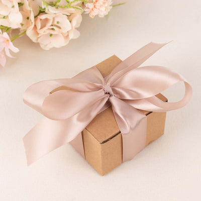 Brown gift box with a pink satin ribbon on a neutral background.