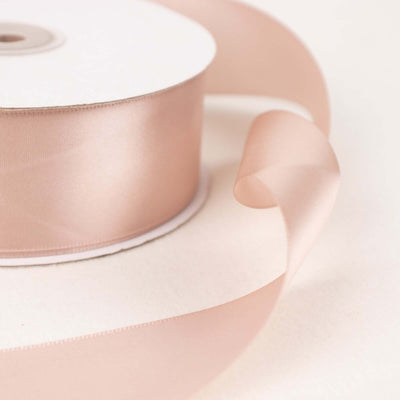 Satin ribbon roll in soft blush pink with flowing ribbon