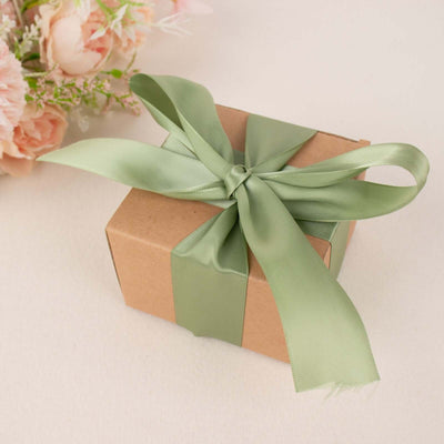 Gift box with green ribbon and flowers in the background.
