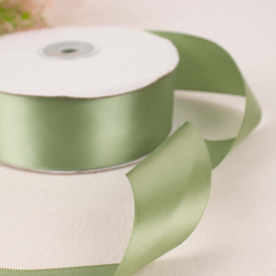 Green satin ribbon on a spool with a loose end