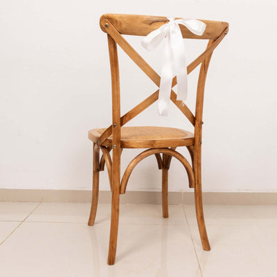 Wooden cross-back chair with a white ribbon, studio-style isolation shot.