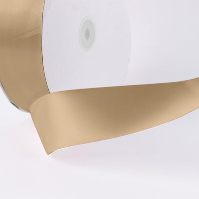 Gold satin ribbon corner detail on white background
