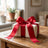 Gift box with red ribbon bow on a wooden table in a cozy living room
