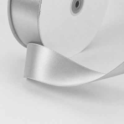 Silver satin ribbon on white gift box close-up