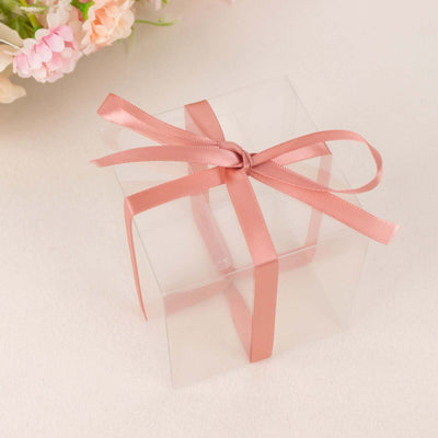 Clear gift box with a pink ribbon on a soft background.