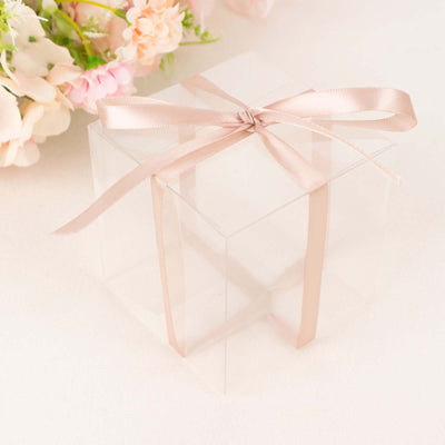 Clear gift box with a satin ribbon bow on a neutral background