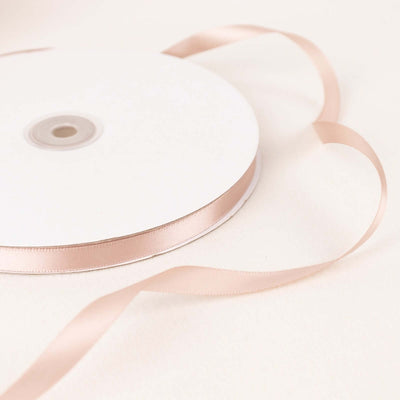 Pink satin ribbon roll on a white background