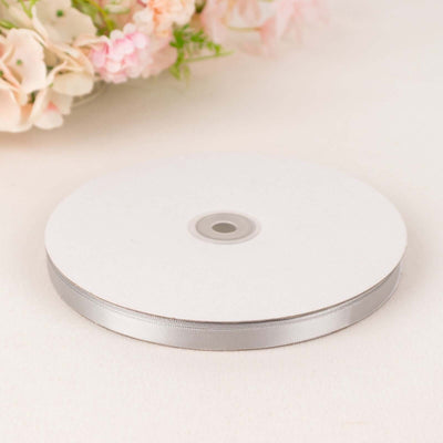 Silver ribbon spool on a white background.