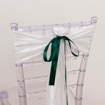 White chair sash with green ribbon tied in a bow.