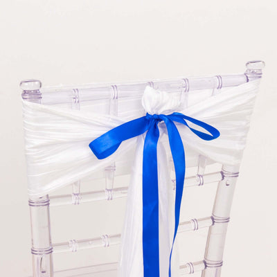 Transparent chair with white fabric and blue ribbon decoration.