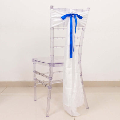 Clear acrylic chair with white and blue satin bow on the back.