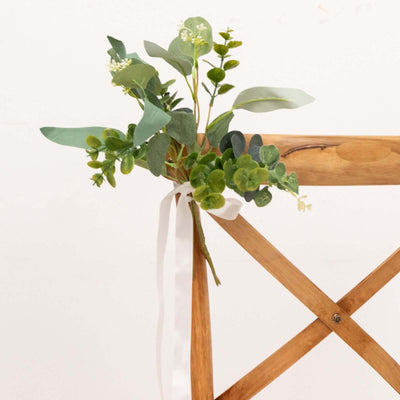 Floral arrangement tied with ribbon on wooden chair