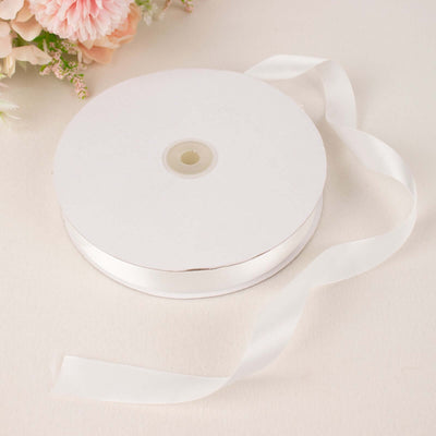 White satin ribbon on a roll with a flowing tail.