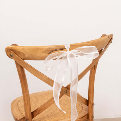 Wooden chair with a white ribbon tied on the back