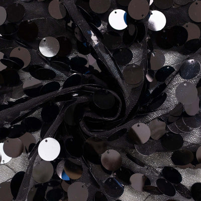 Black sequin fabric with a shiny finish arranged in a swirling pattern.