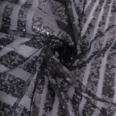 Black sequin fabric with a spiral pattern and shimmering texture.