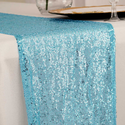 Blue sequin table runner on a white tablecloth