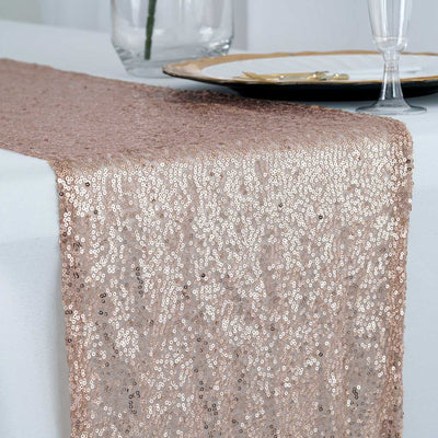 Rose gold sequin table runner on a white table setting.