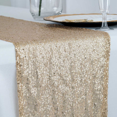 Gold sequin table runner on a white table setting.