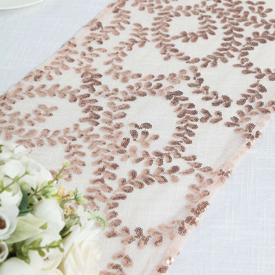 Rose gold sequin table runner with intricate leaf pattern on a light background.