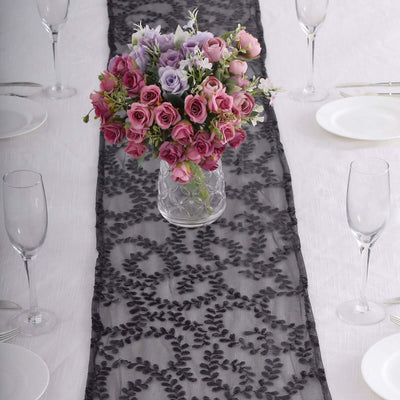 Elegant black lace table runner with a bouquet of pink and purple roses.