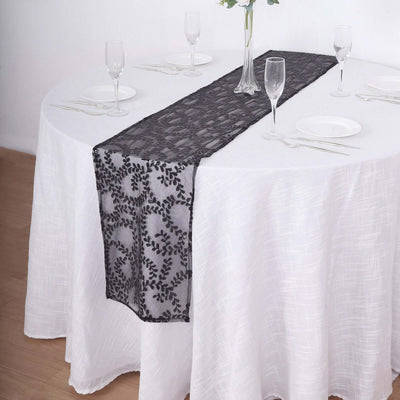 Black lace table runner on a white tablecloth with dinnerware and glasses.
