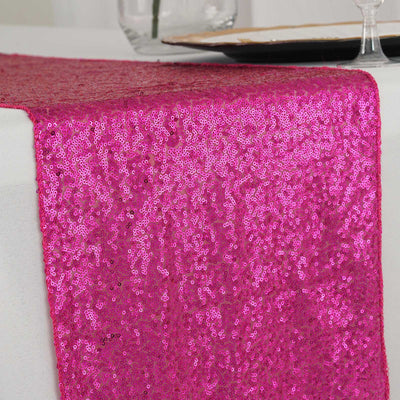 Pink sequin table runner on a white table setting.