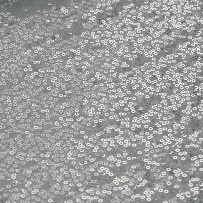 Silver sequin fabric texture with sparkling shimmer.