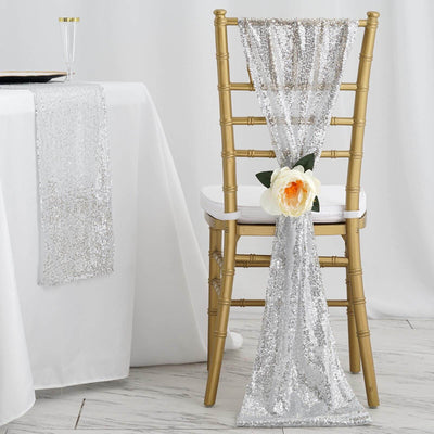 Silver sequin chair sash with flower decoration on a gold chair.