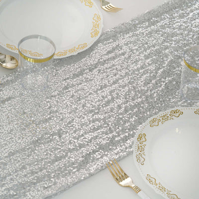 Silver sequin table runner with elegant gold-accented dinnerware.