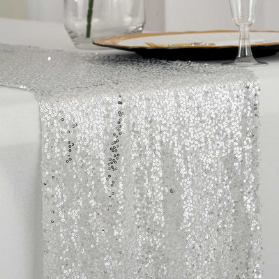 Silver sequin table runner draping elegantly over a table.