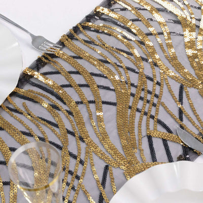 Gold and black sequined table runner with wavy design on a plain background.