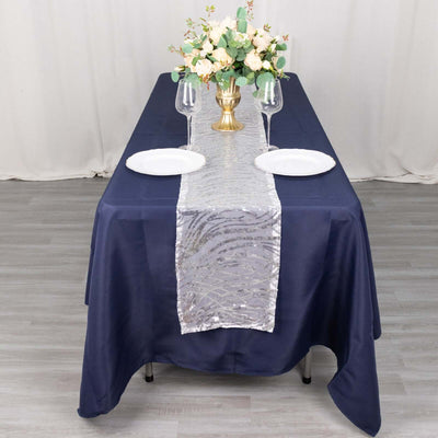Elegant navy tablecloth with silver sequin runner and floral centerpiece.