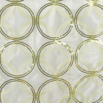 Sequined fabric with circular patterns in gold and green tones.