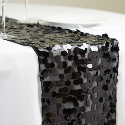 Black sequin table runner on a white tablecloth.