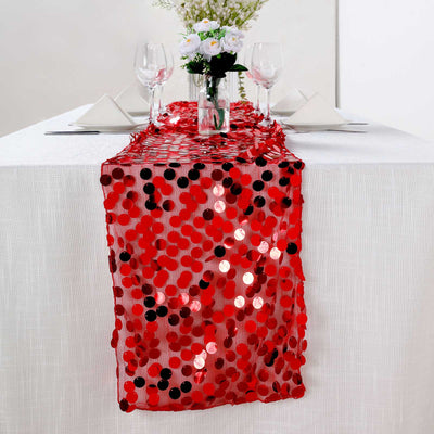 Red sequin table runner on a white table with elegant dining setup.