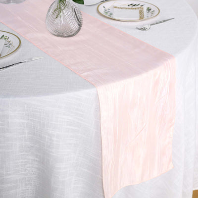 Pink satin table runner on a textured white tablecloth.