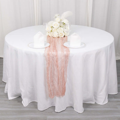 Elegant table setting with floral centerpiece and draped fabric.